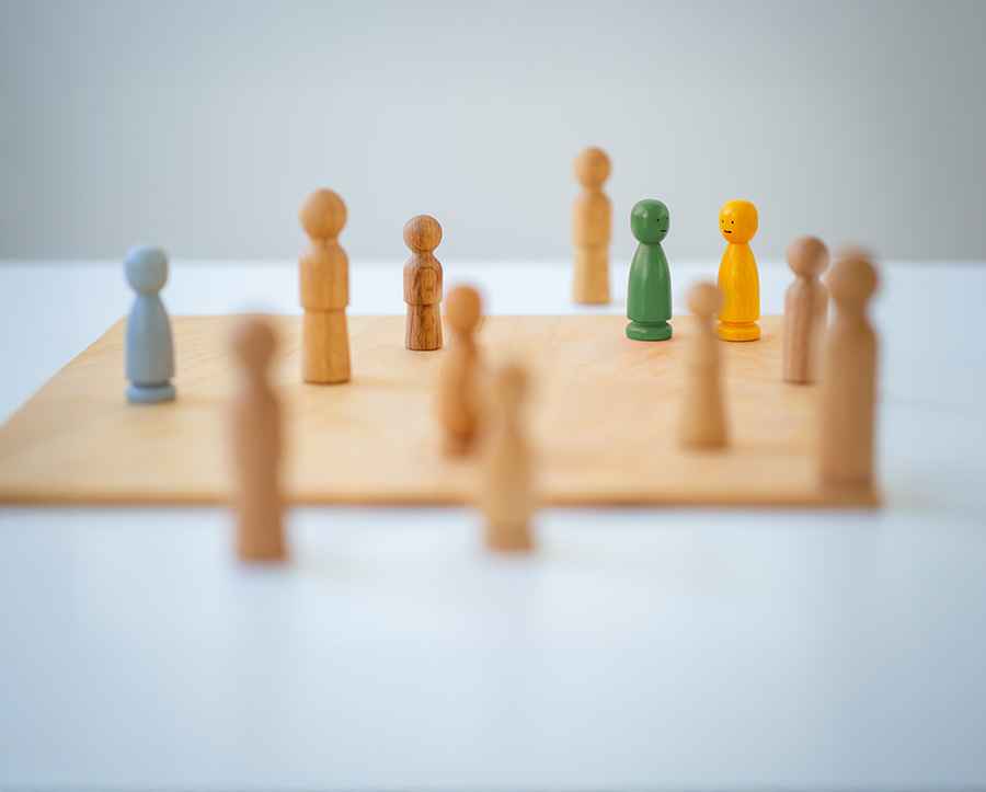 Holzfiguren als Symbol für Beziehungen und Systeme in der systemischen Therapie
